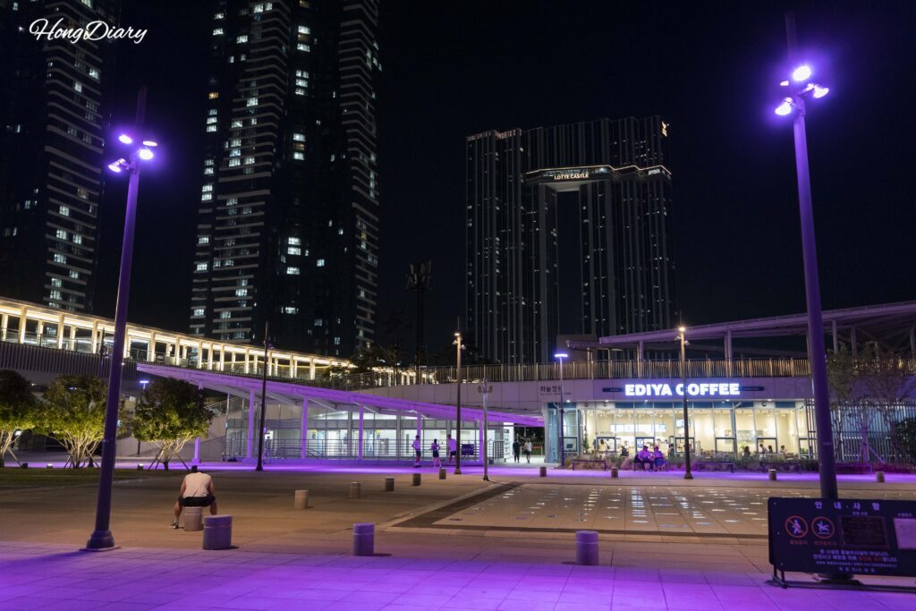 Ediya Coffee cafe at the entrance of North Port Waterfront Park with Hyeopseong Marina G7 and Lotte Castle de Mer towers in the background