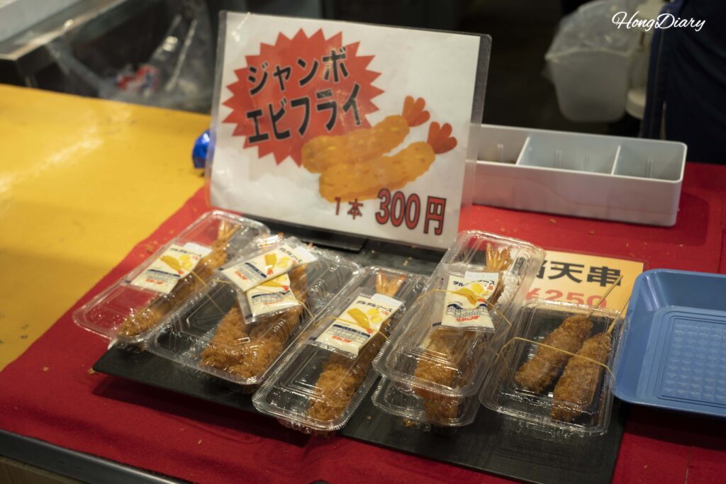 Close-up of golden fried shrimp tempura sold at a stall in Karato Market, Shimonoseki, priced at 300 yen