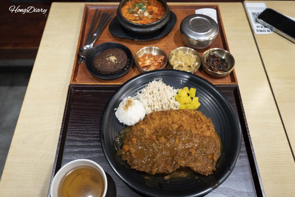Primer plano de la milanesa de cerdo gigante (wang donkkaseu) en Plating, aeropuerto de Gimhae