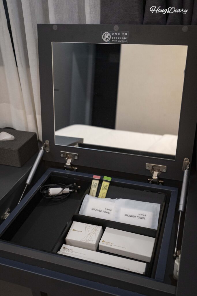 Complimentary amenities including toothbrush, razor, and kombucha tea bags on the desk at Giverny Hotel Gyeongju