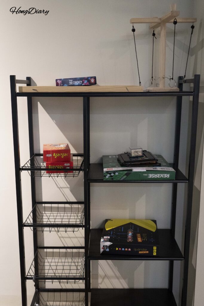 Shelf of free board games available for guests at Giverny Hotel Gyeongju basement lounge