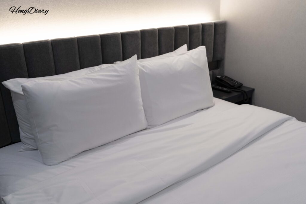 Double bed with white bedding and 65-inch Smart TV in the Deluxe room at Giverny Hotel Gyeongju