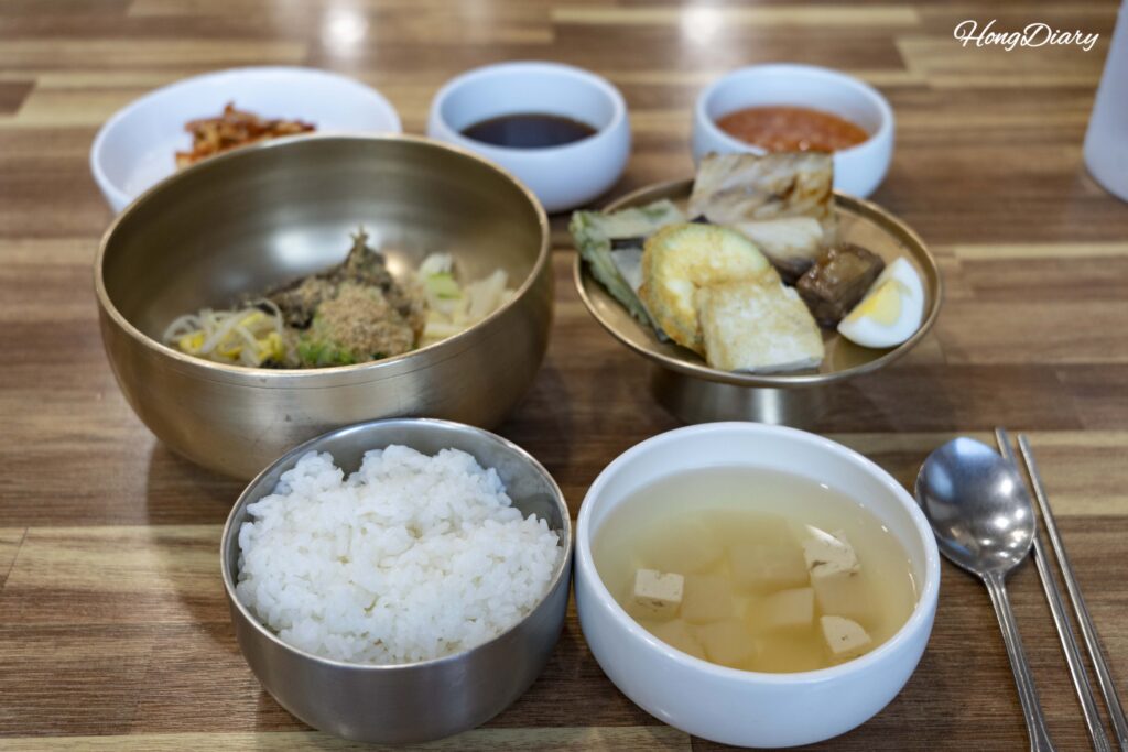 Set de heotjesabap en Mat 50-nyeon de Andong — bibimbap con salsa de soja, seis tipos de namul, jeon y sopa servidos en vajilla de latón