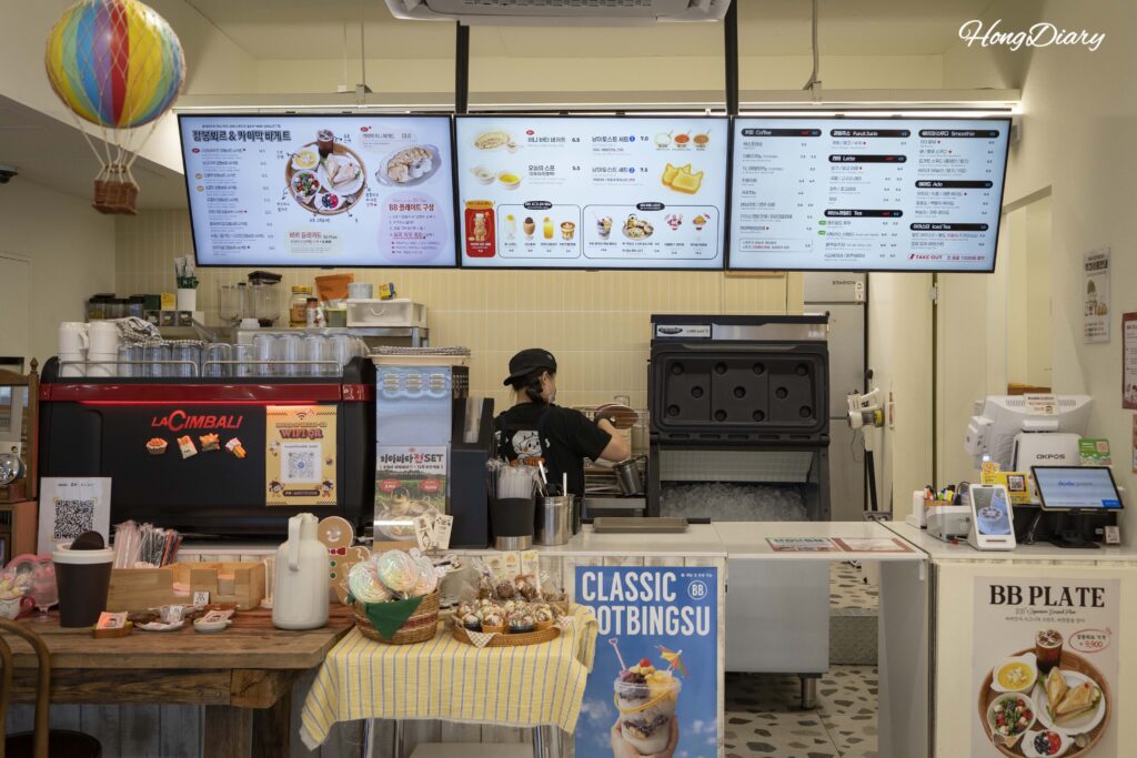 Mostrador de pedidos y cocina abierta de la cafetería House of Bread BB en Gwangalli Busan