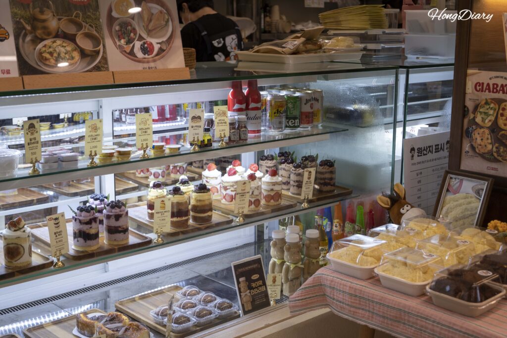 Glass display case filled with fresh cakes and desserts at House of Bread BB Gwangalli Busan