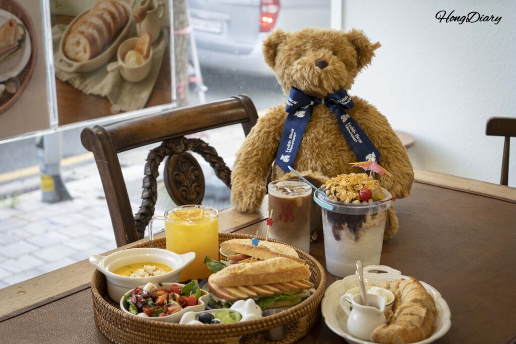 Table set with ordered brunch items and a stuffed teddy bear at House of Bread BB Gwangalli