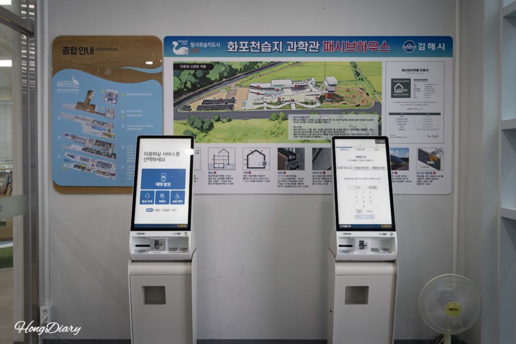 Digital reservation kiosk and visitor information board inside the Hwapocheon Wetland Science Museum entrance hall