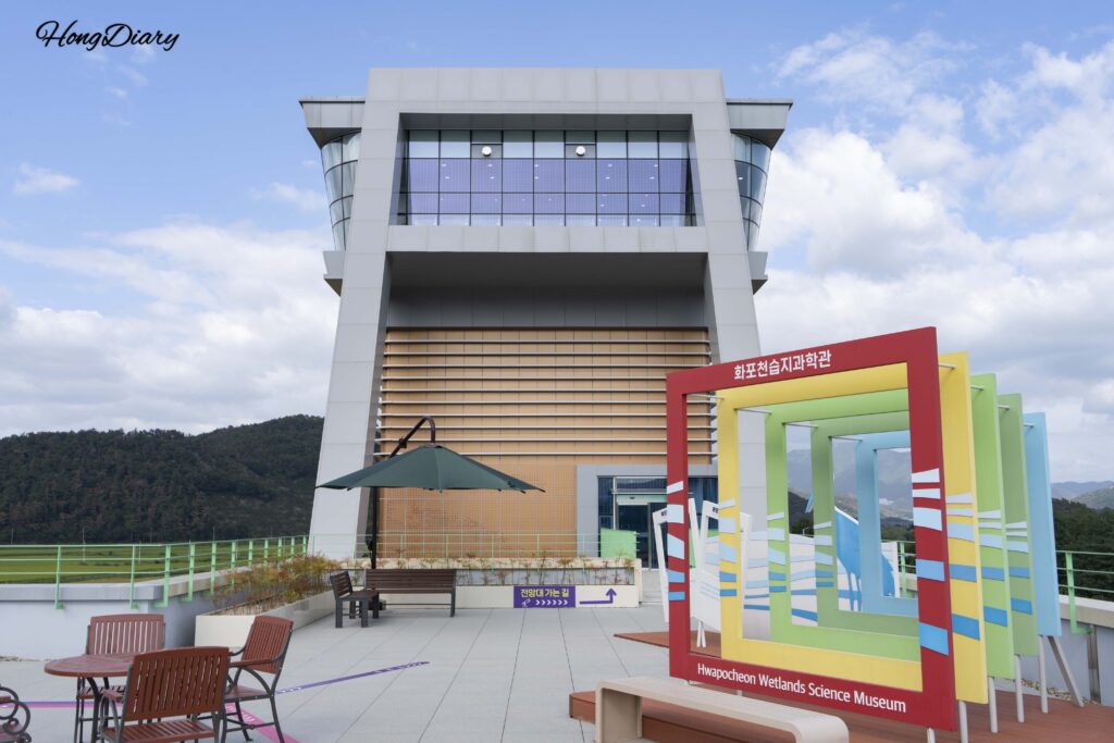 Open-air rooftop photo deck on the RF level of the Hwapocheon Wetland Science Museum with views of the wetland in Gimhae