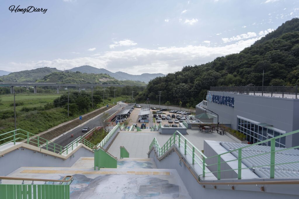 Staircase descending from the Hwapocheon Bird Observatory Tower with a view of the surrounding landscape in Gimhae