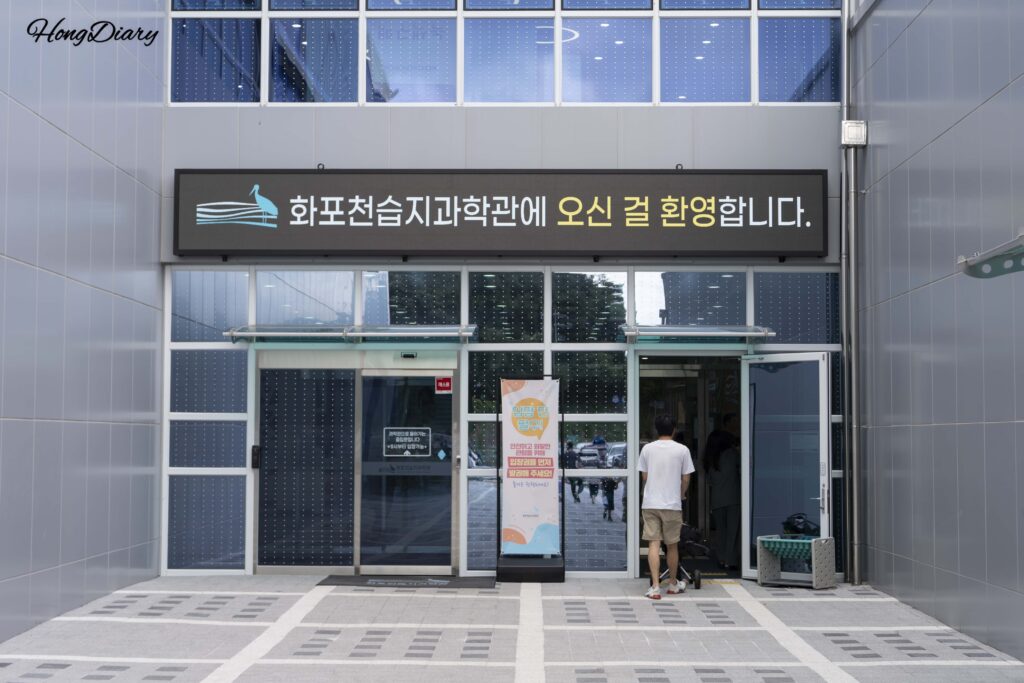Entrance of the Hwapocheon Wetland Science Museum showing the main doorway and modern facade in Gimhae