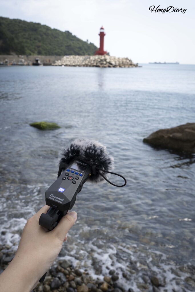Recording ocean sounds with a field recorder at Jungni Beach near Huinnyeoul Culture Village in Busan