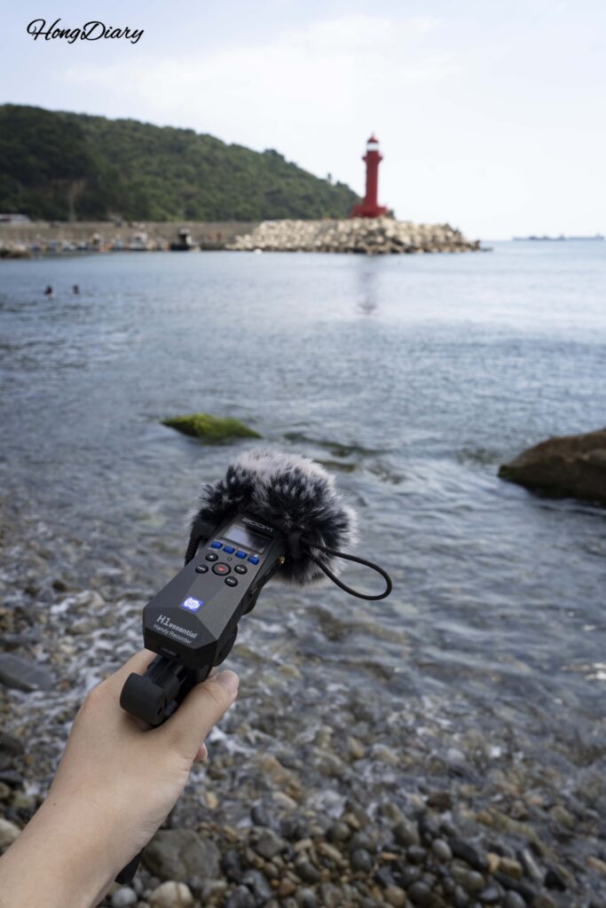Grabando sonidos del océano con una grabadora de campo en la Playa Jungni, cerca de Huinnyeoul en Busan