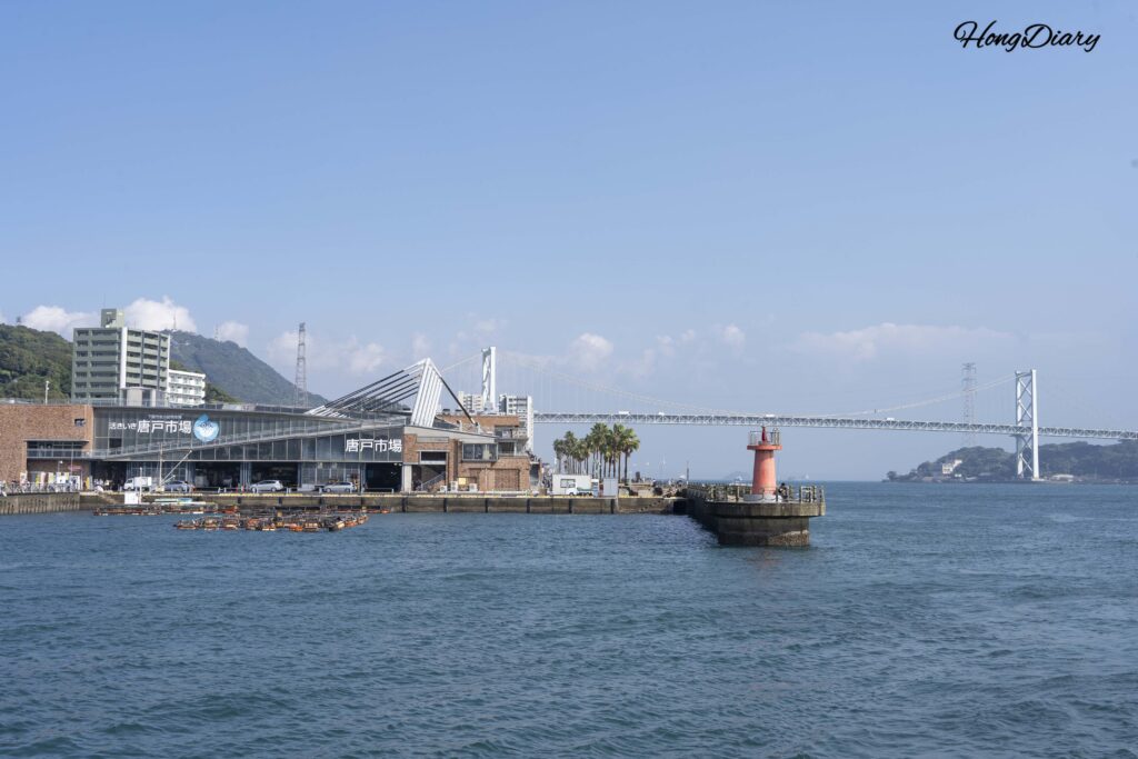 View from Kaikyokan aquarium area in Shimonoseki, showing the ocean, Karato Market in the distance, and the Kanmon Bridge