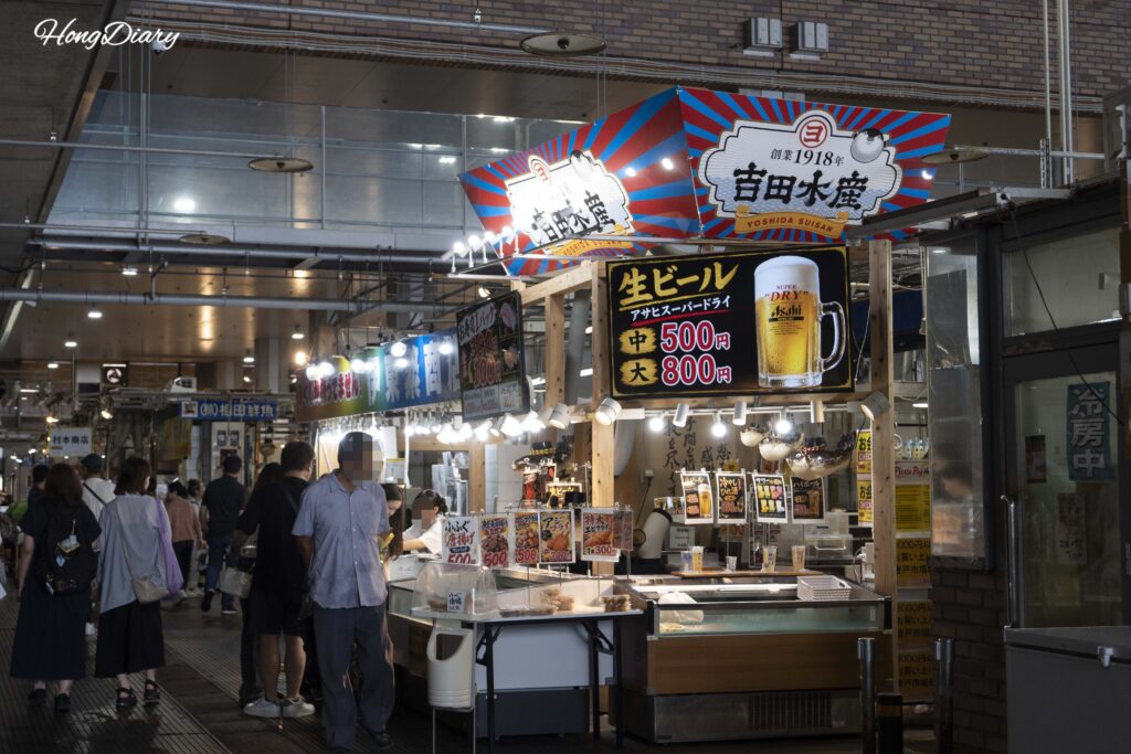 A stall at Karato Market selling Asahi draft beer, with a medium glass priced at 500 yen and a large at 800 yen