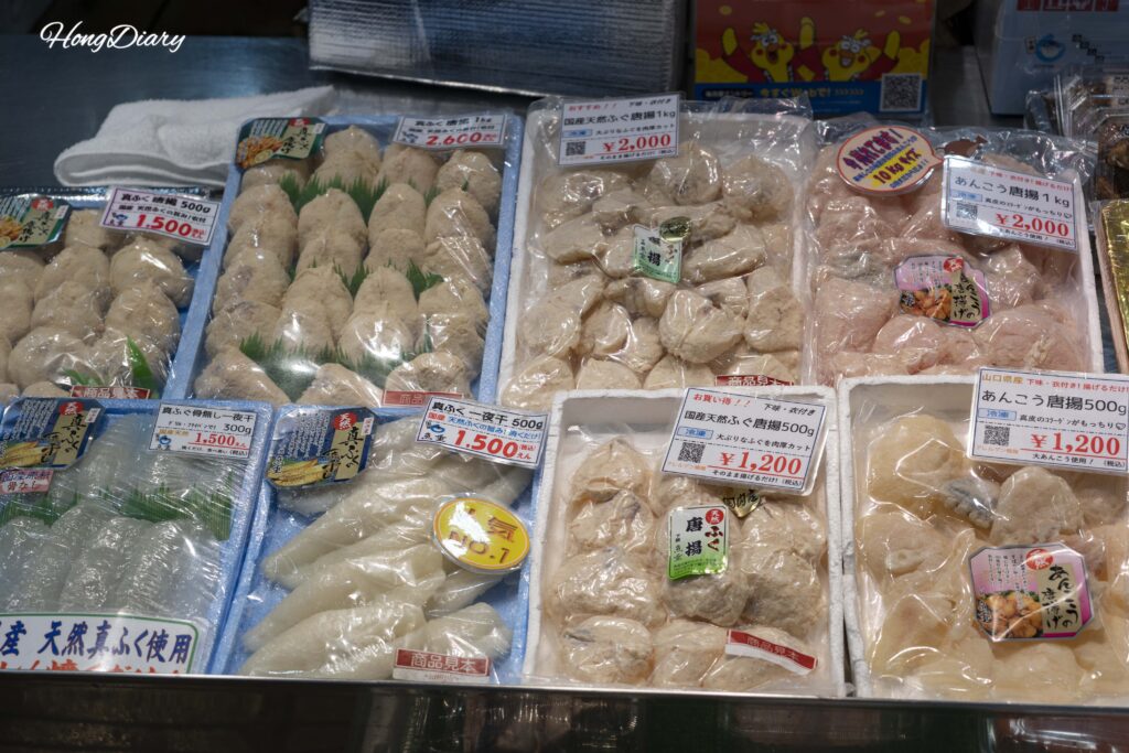 Packaged fishcake and processed seafood products for sale at Karato Market, priced from 1200 to 2600 yen