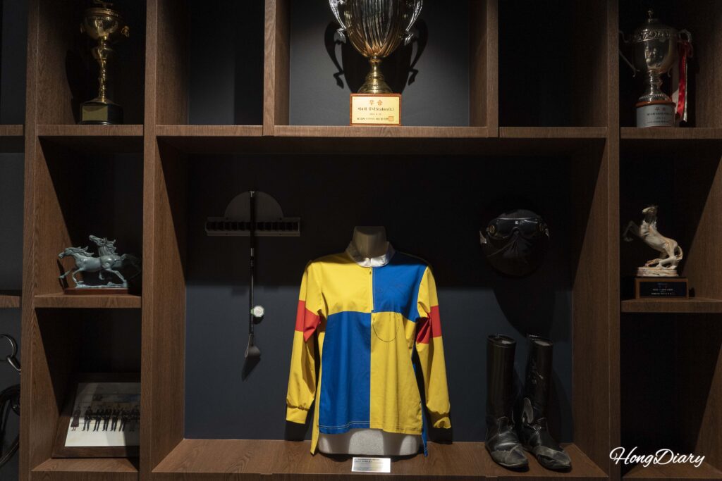 Champion jockey uniform and memorabilia on display inside Heritage Hall at Let's Run Park Busan