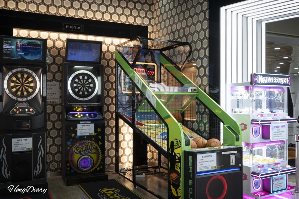 Families and children playing arcade games inside the Rookie Zone at Let's Run Park Busan
