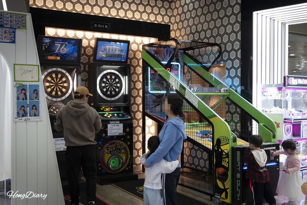 Familias y niños jugando a juegos de arcade dentro de Rookie Zone en Let's Run Park Busan