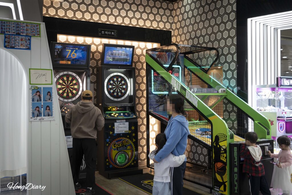レッツランパーク釜山のルーキーゾーン内でアーケードゲームを楽しむ家族と子どもたち