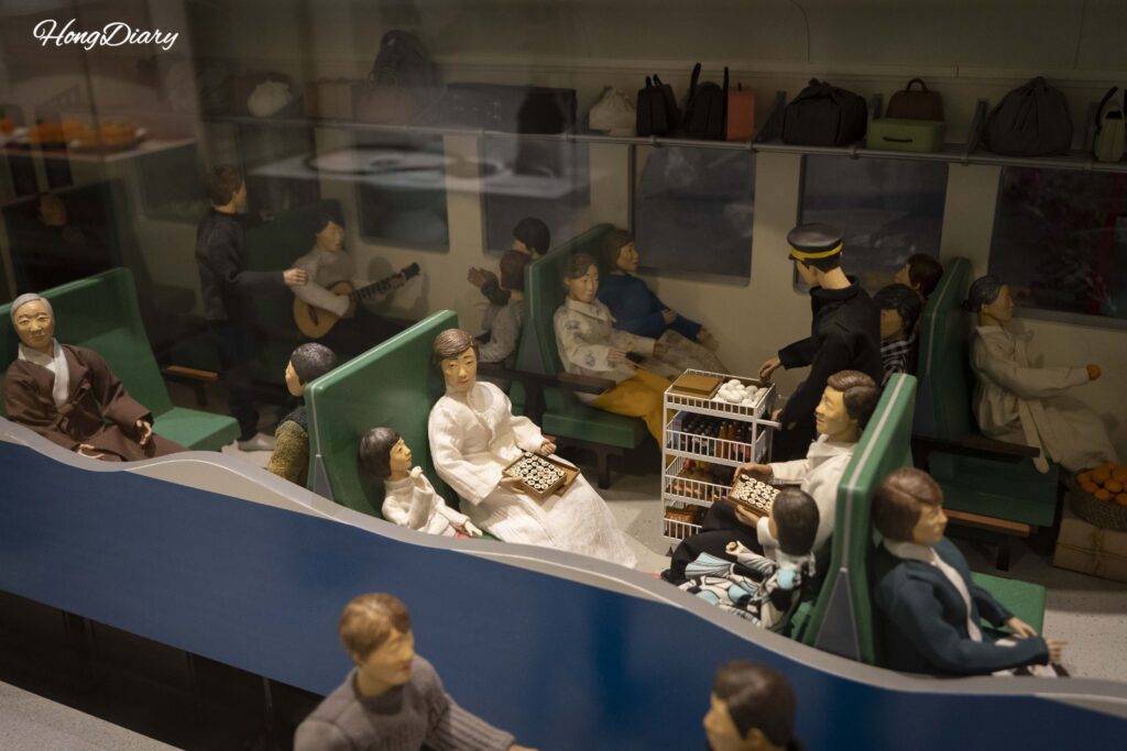 Miniature scale model of a vintage Korean train with passenger figures at Jinyeong Railway Museum