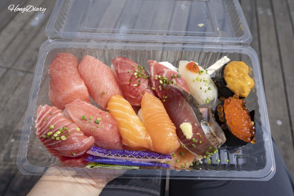A second sushi tray from Karato Market featuring horse mackerel, salmon roe, tuna, sea urchin, scallop, salmon, and egg nigiri