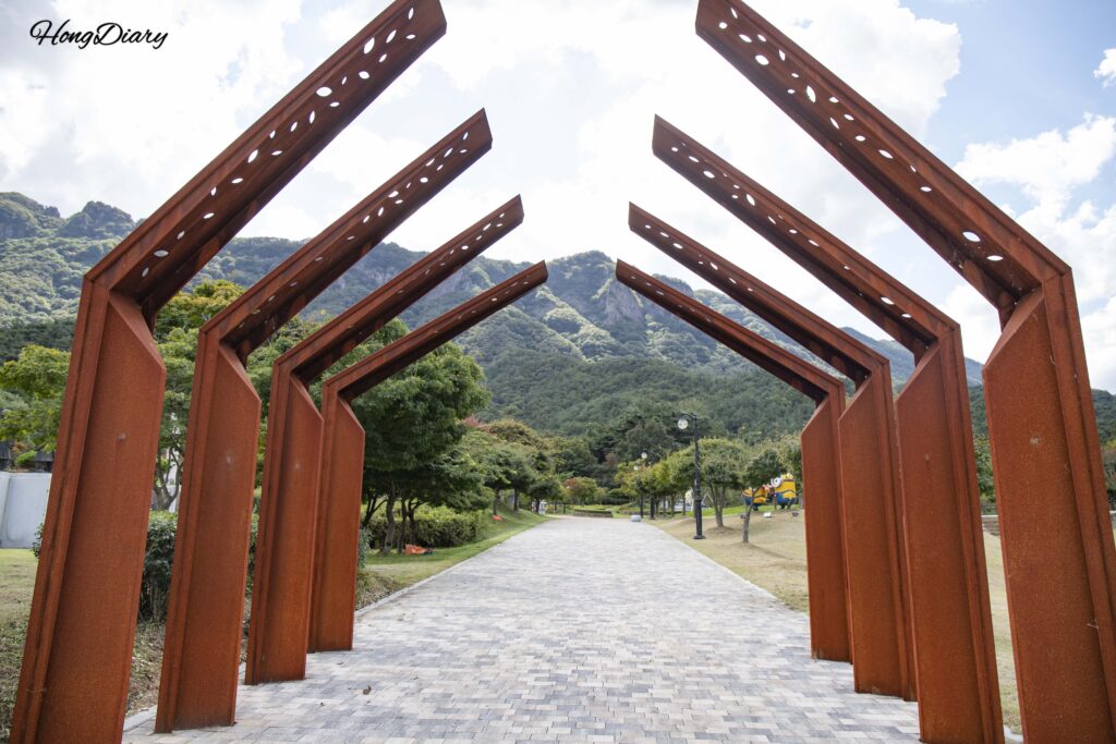Outdoor sculpture at Naejangsan Sculpture Park with Naejangsan mountain ridgeline visible in the background