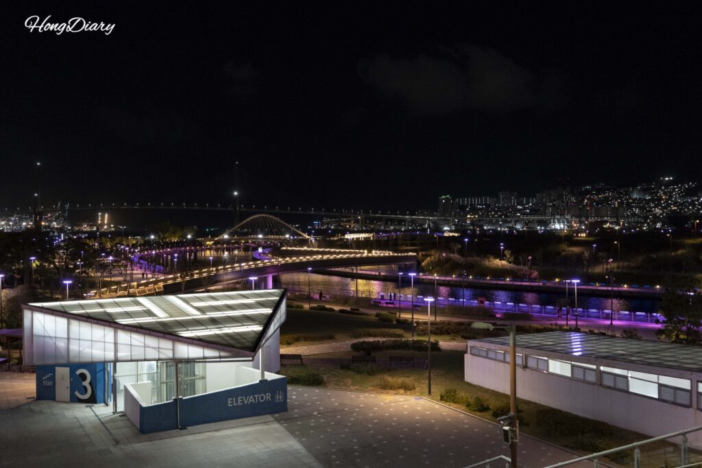 Overhead view of North Port Waterfront Park Busan at night showing the full park layout with lit walkways and waterfront