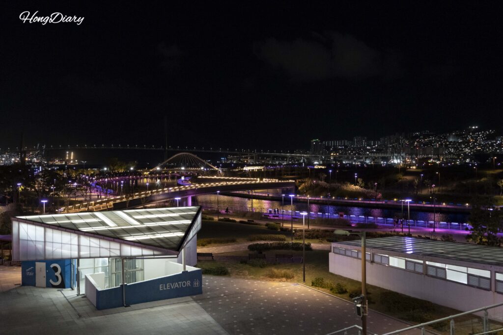 Vista aérea nocturna de North Port Waterfront Park en Busan mostrando el diseño completo del parque con senderos iluminados