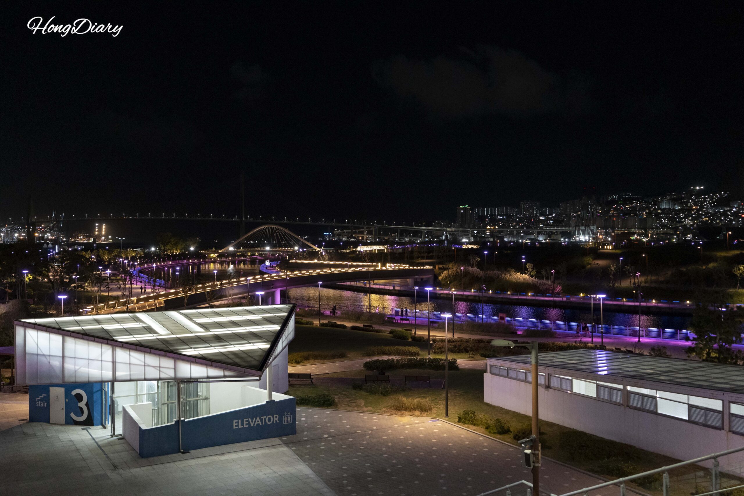 上空から見下ろした北港親水公園の夜景全体像。照明付き散策路とウォーターフロントが広がる
