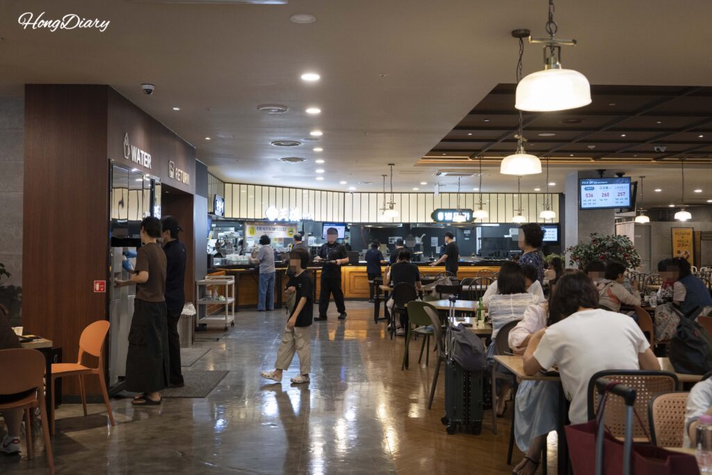 Self-service water station, tray return area, and food pickup counter at Plating food court in Gimhae Airport