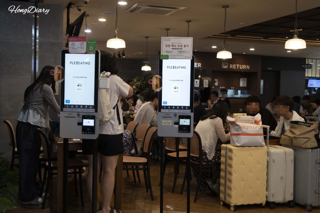 金海空港プレイティングのタッチパネル券売機で注文する旅行者たち