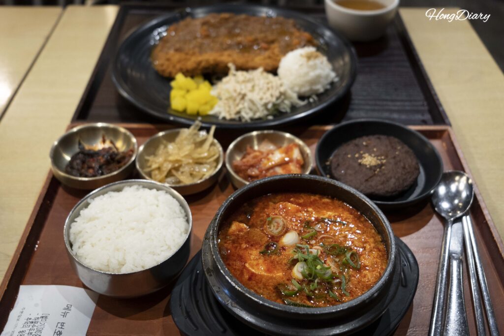 Milanesa de cerdo gigante y set de sundubu jjigae de mariscos pedidos en Plating, aeropuerto de Gimhae