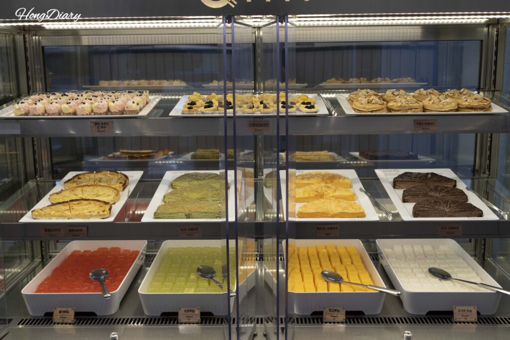 Estación de postres en QooQoo Yangsan con pasteles, pan y repostería