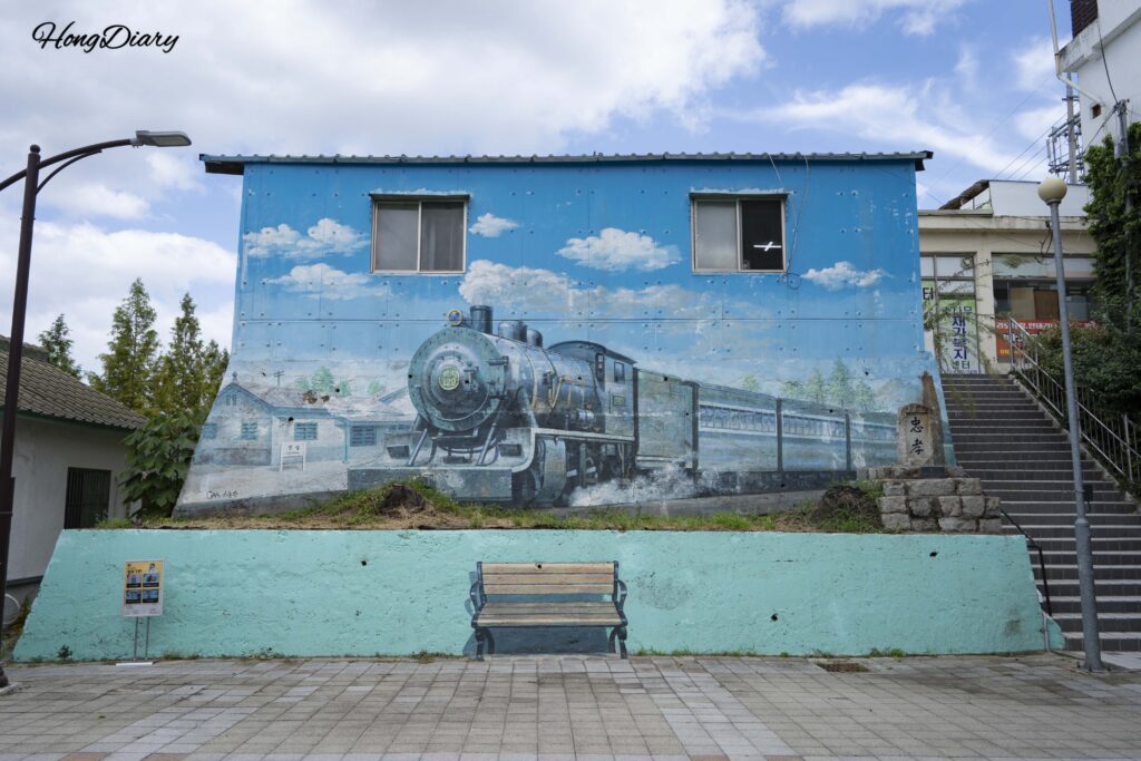 Mural con temática ferroviaria pintado en un edificio antiguo del Parque Histórico de Jinyeong