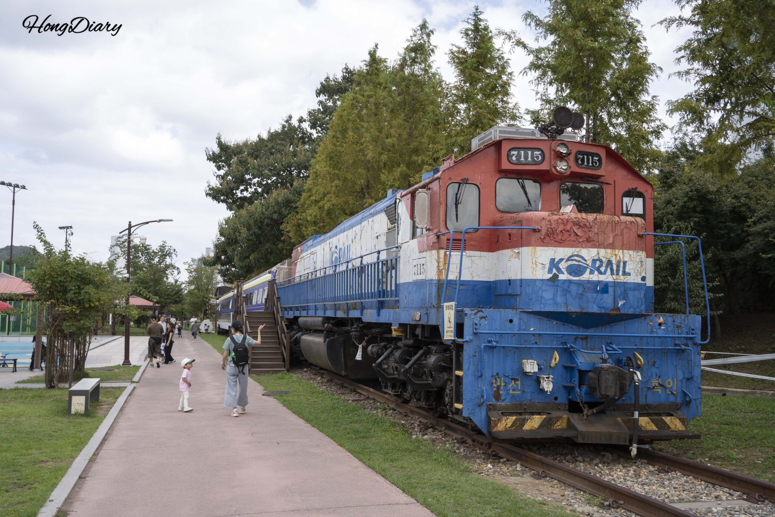 Retired Korail diesel locomotive No. 7115 with passenger cars on preserved track at Jinyeong History Park in Gimhae
