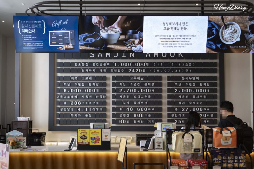 Interior entrance of Samjin flagship with visitor count and sales milestones displayed on the wall