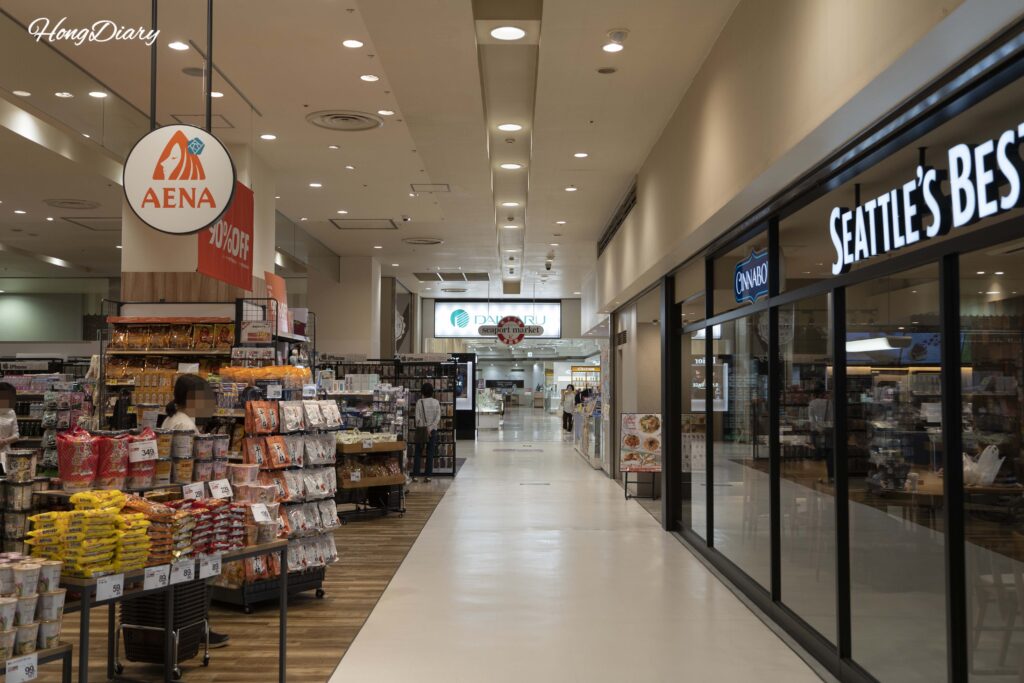 Interior view of Sea Mall showing Aena variety shop, Seattle's Best Coffee, and walkway connecting to Daimaru Department Store