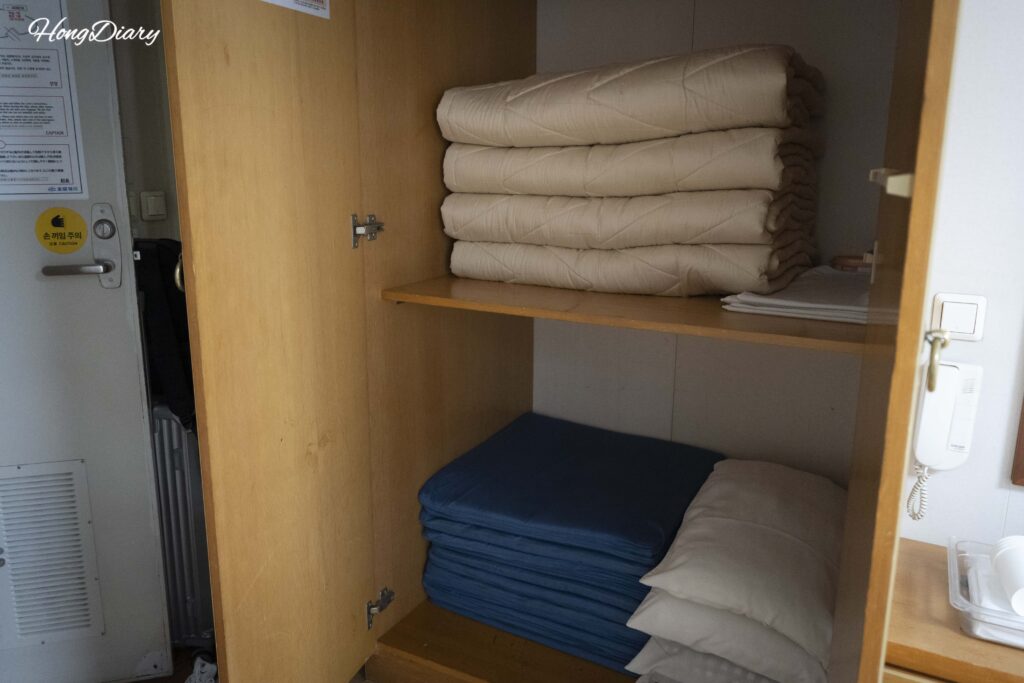 Futon bedding and life jackets stored inside the closet of the Seonghee tatami cabin