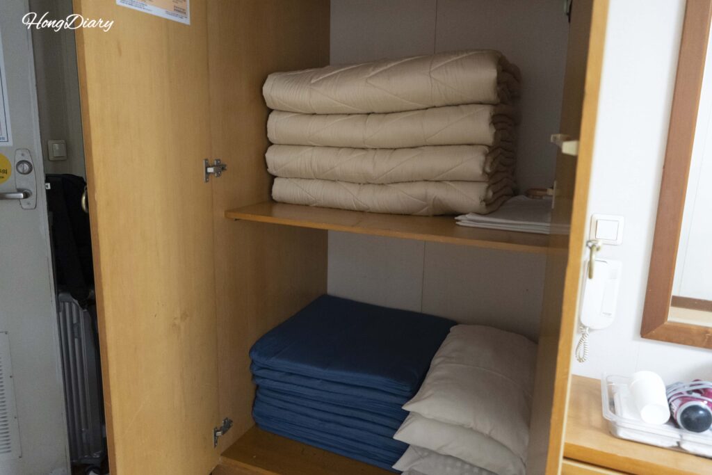 Futones, almohadas y chalecos salvavidas guardados en el armario de la cabina coreana del Seonghee