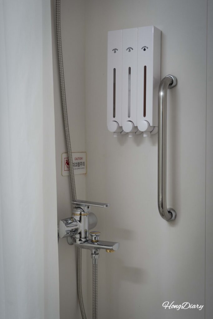 Área de ducha dentro del baño privado de la cabina coreana del ferry Seonghee