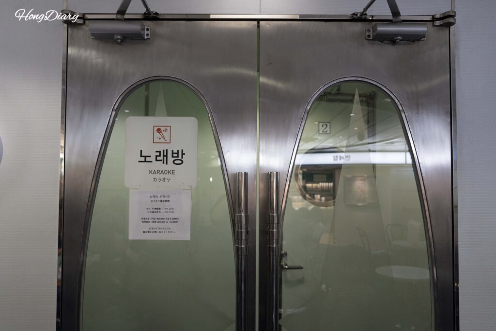 Entrance to the karaoke room on the Seonghee ferry with posted hours and pricing sign