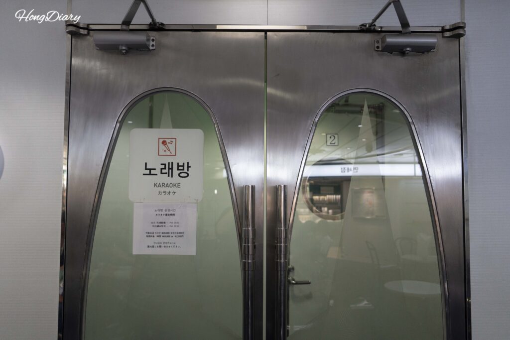 Entrada de la sala de karaoke del ferry Seonghee con aviso de horario y precios