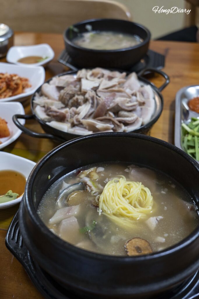 Wheat noodles added to Donsamjeonboktang pork ginseng abalone soup at Seonjeongmun Dwaeji Gukbap in Busan
