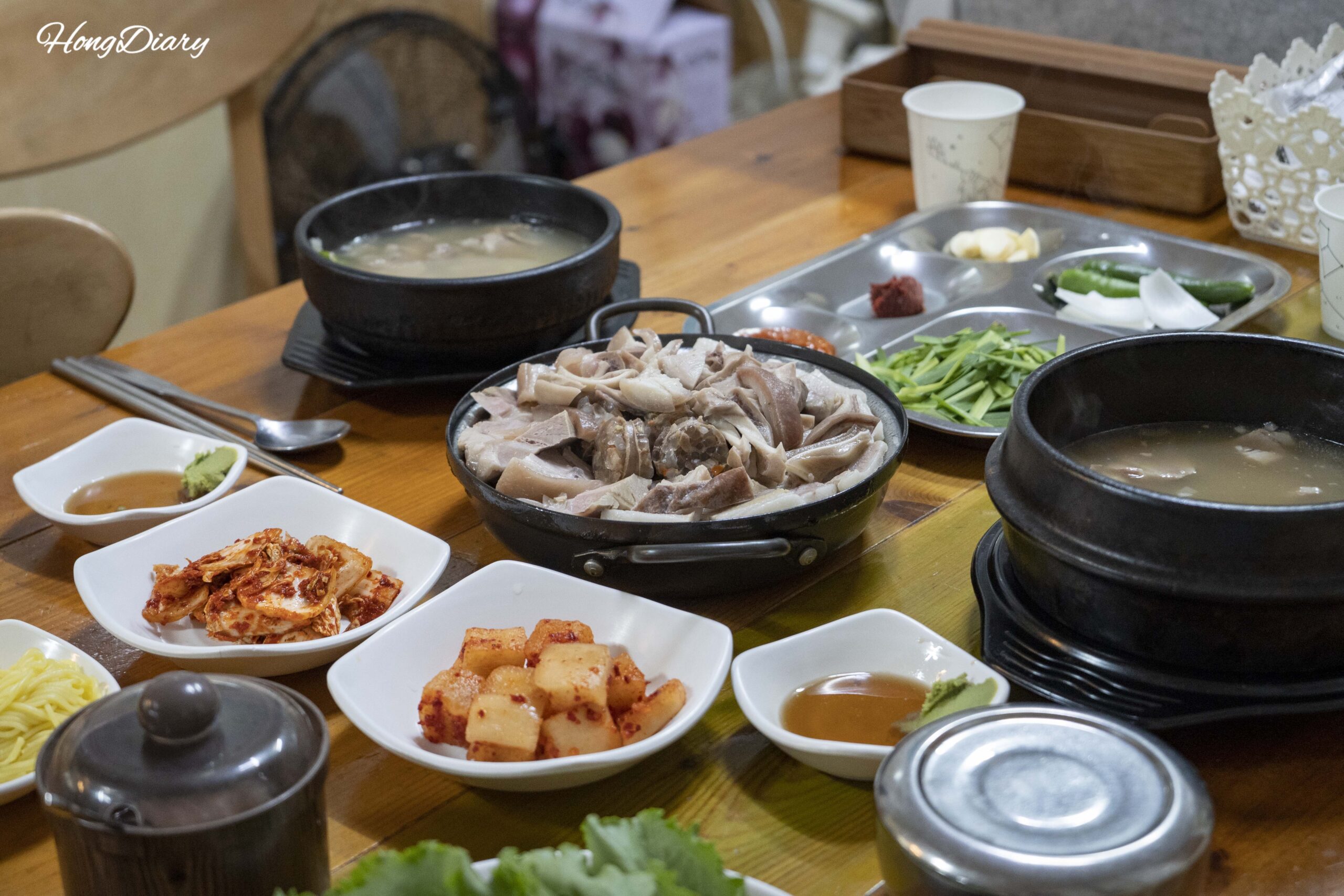 Mesa completa en Seonjeongmun Dwaeji Gukbap con dwaeji gukbap, donsamjeonboktang y suyuk con acompañamientos