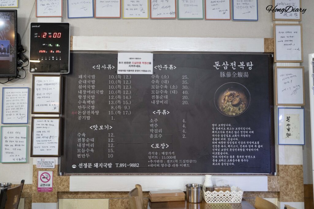 Chalkboard menu at Seonjeongmun Dwaeji Gukbap showing prices for pork soup, donsamjeonboktang, and side dishes in Danggam-dong, Busan