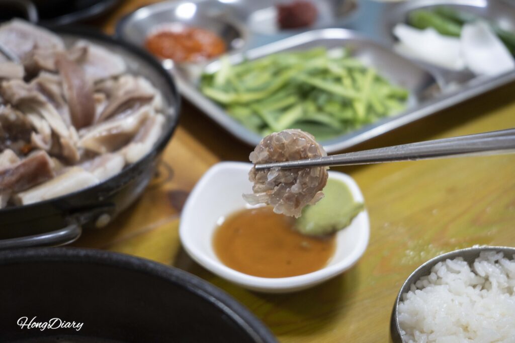 釜山ソンジョンムン テジクッパで提供されたスンデ（韓国式腸詰め）をタレにつけて食べる様子