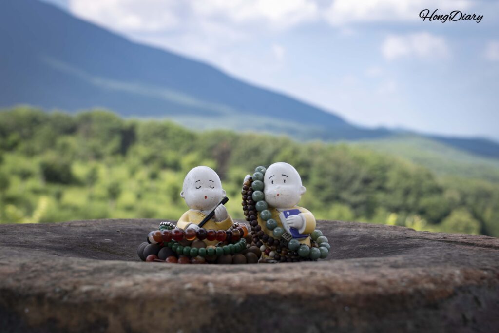 Pequeñas figuritas de cerámica de monjes junto a rosarios budistas (yeomju) dejados por visitantes en la ermita Seounam