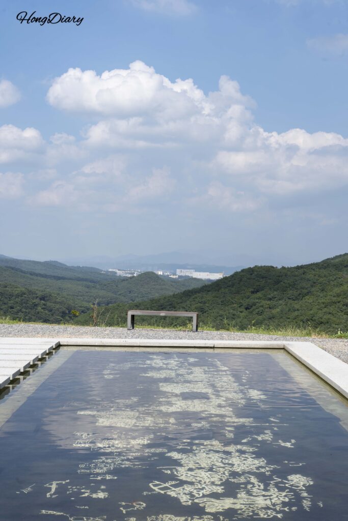 西雲庵の水中螺鈿漆器展示に青空と雲が映り込む縦構図の写真