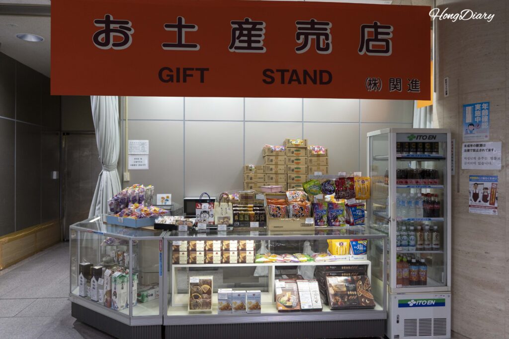 Pequeña tienda en el segundo piso de la Terminal Internacional del Puerto de Shimonoseki con snacks, bebidas y cajas de recuerdos