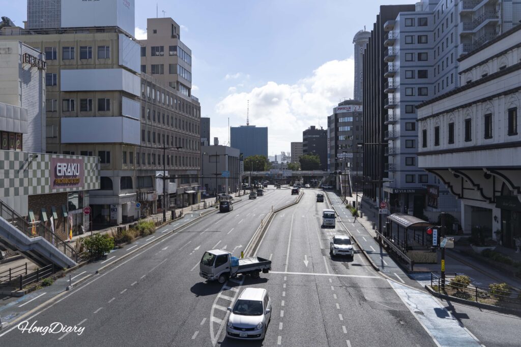 Vista a nivel de calle desde la pasarela de Shimonoseki con la Torre Kaikyo Yume parcialmente visible a la derecha